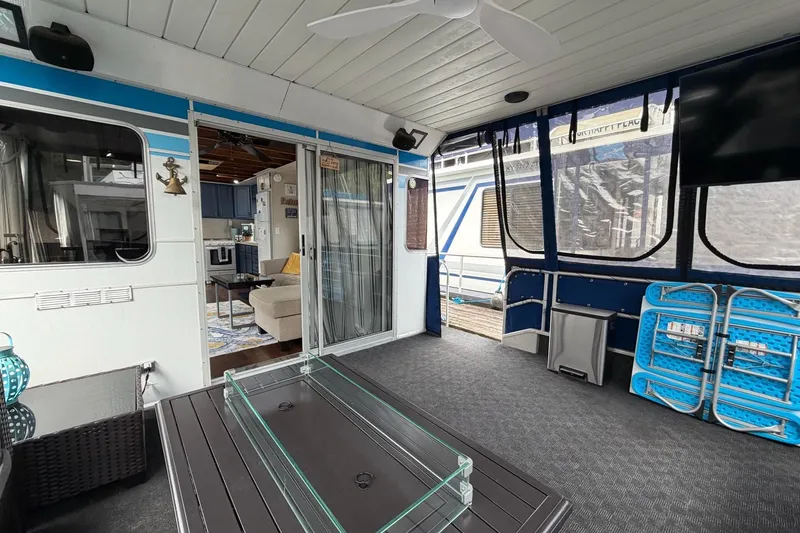 Slide: The Image of 1987 Jamestowner 14x60 houseboat interior with modern furnishings and enclosed deck area. - 3
