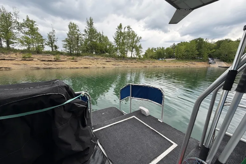 Slide: The Image of 1987 Jamestowner 14x60 houseboat docked on a serene lake with lush greenery. - 30