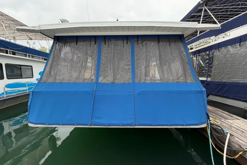 Slide: The Image of 1987 Jamestowner 14x60 houseboat with blue canvas enclosure at dock. - 33