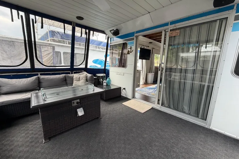 Slide: The Image of Interior of a 1987 Jamestowner 14x60 houseboat with cozy seating and glass table. - 4