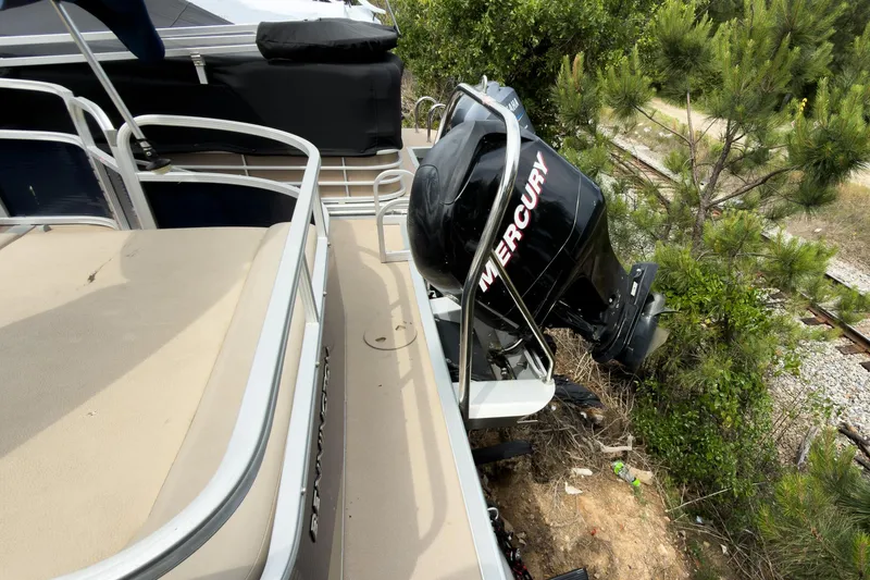 Slide: The Image of 2006 Bennington 2275RL pontoon boat with Mercury outboard motor near greenery. - 10