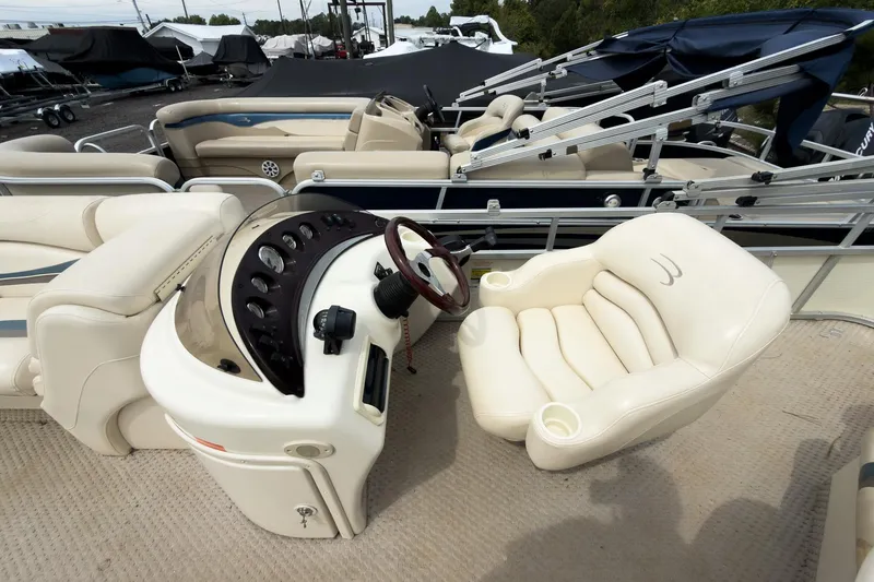 Slide: The Image of 2006 Bennington 2275RL boat interior with steering console and plush seating. - 6