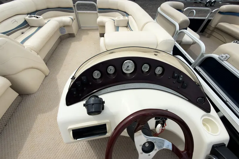 Slide: The Image of 2006 Bennington 2275RL pontoon boat interior with steering console and plush seating. - 7