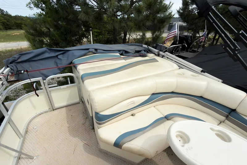 Slide: The Image of 2006 Bennington 2275RL pontoon boat with cushioned seating and table, parked outdoors. - 8