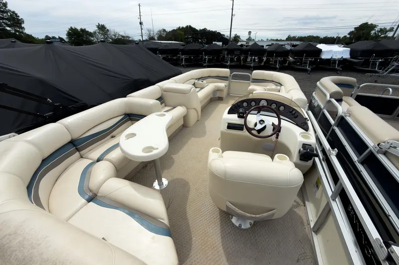 Slide: The Image of 2006 Bennington 2275RL pontoon boat interior with beige seating and steering console. - 9