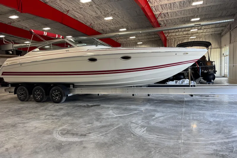 The Image of 2001 Formula 330 Sun Sport boat on trailer in indoor storage facility. - 1