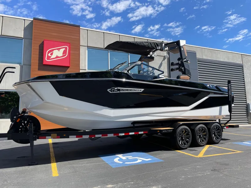 Slide: The Image of 2026 Nautique G25 boat parked in front of a building. - 2