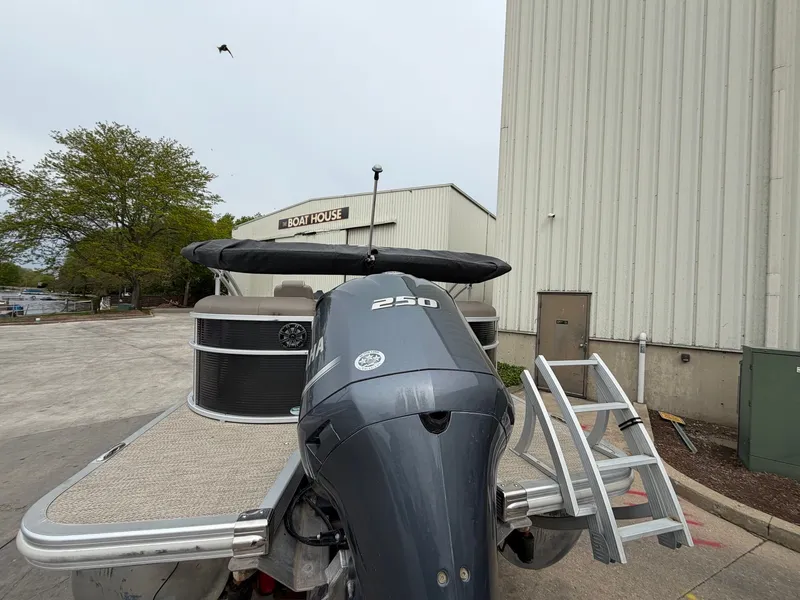 Slide: The Image of 2019 Bennington 23SX pontoon boat in front of a boathouse. - 4