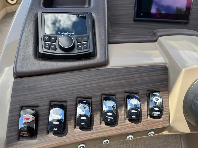 Slide: The Image of Control panel of 2021 Bennington 25QXSBA ESP TRI boat with switches and radio. - 19
