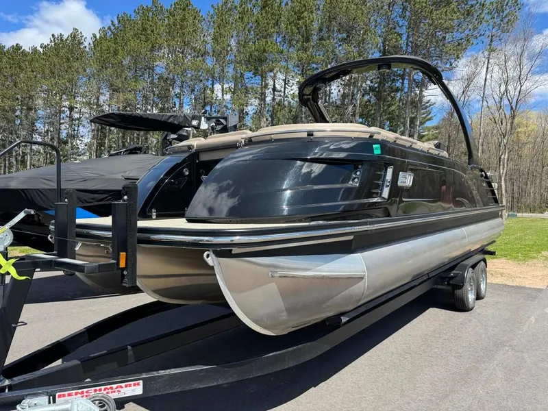 Slide: The Image of 2021 Bennington 25QXSBA ESP TRI pontoon boat on trailer outdoors. - 5