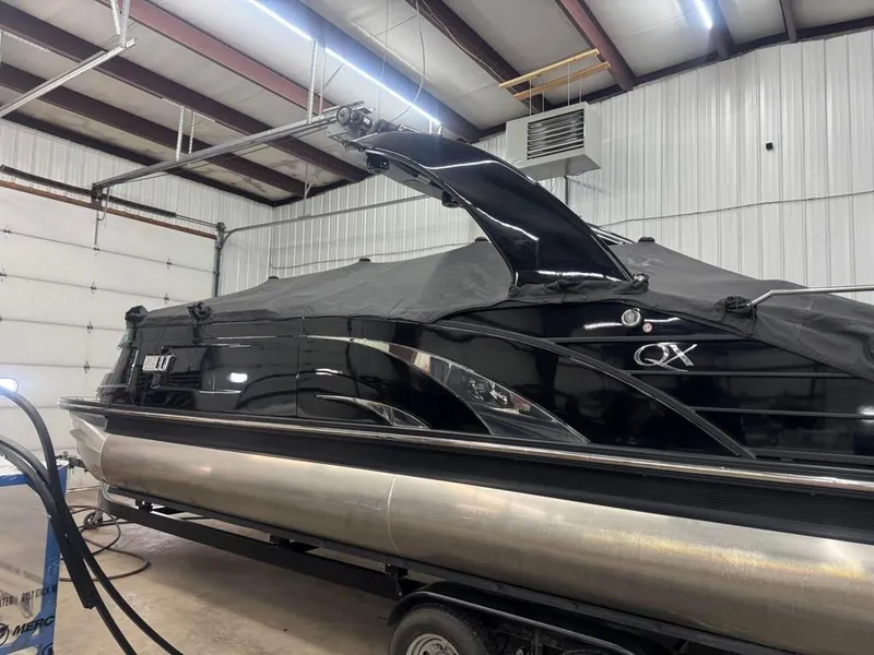 Slide: The Image of 2021 Bennington 25QXSBA ESP TRI pontoon boat in storage facility. - 9
