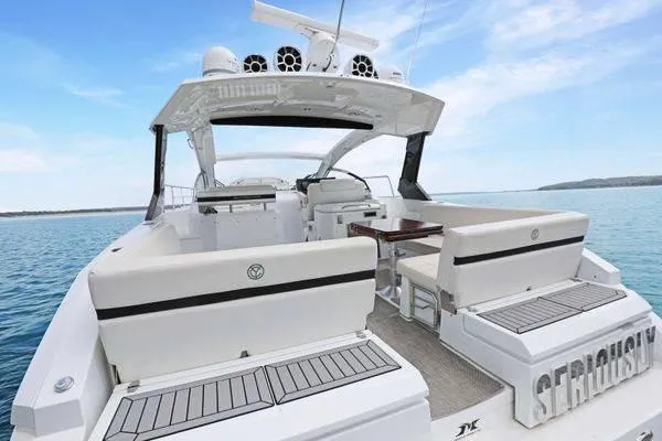 Slide: The Image of 2018 Cruisers Yachts 390 Express Coupe on serene water, showcasing spacious deck and seating. - 11