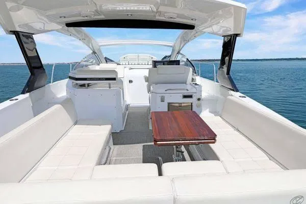 Slide: The Image of 2018 Cruisers Yachts 390 Express Coupe interior with seating and table on open water. - 15
