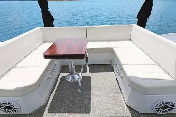 Slide: The Image of 2018 Cruisers Yachts 390 Express Coupe with elegant seating and table on deck. - 16