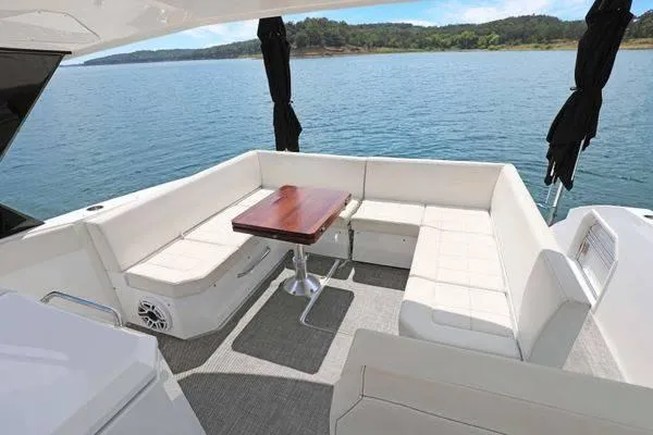 Slide: The Image of 2018 Cruisers Yachts 390 Express Coupe, featuring a luxurious outdoor seating area by the water. - 17