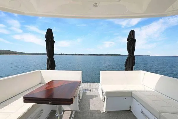 Slide: The Image of 2018 Cruisers Yachts 390 Express Coupe, rear deck view with seating and table, overlooking water. - 21
