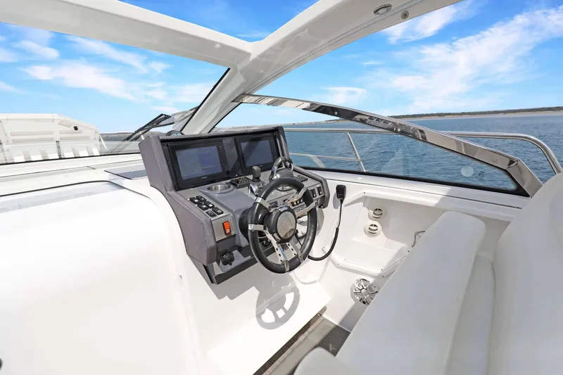 Slide: The Image of 2018 Cruisers Yachts 390 Express Coupe helm with modern controls and ocean view. - 28