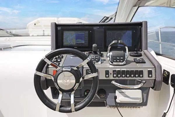 Slide: The Image of 2018 Cruisers Yachts 390 Express Coupe helm with steering wheel and navigation controls. - 31