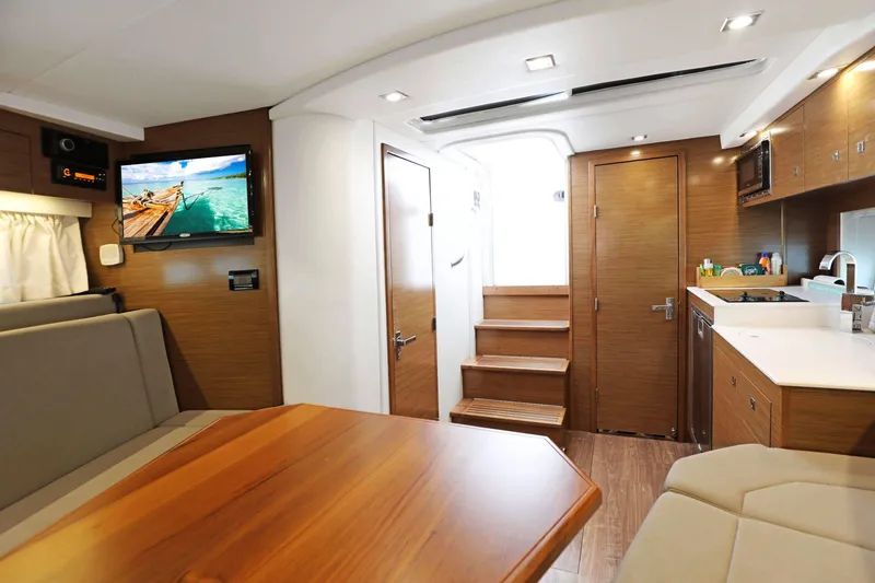 Slide: The Image of Interior of 2018 Cruisers Yachts 390 Express Coupe, featuring modern kitchen and seating area. - 34