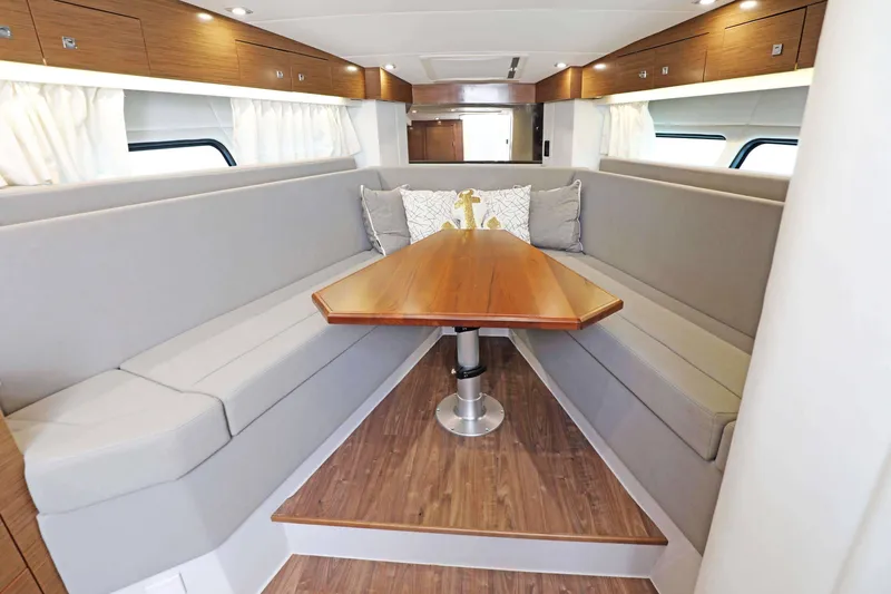 Slide: The Image of Interior of 2018 Cruisers Yachts 390 Express Coupe with elegant seating and wooden table. - 36