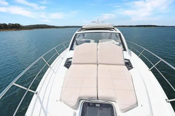 Slide: The Image of 2018 Cruisers Yachts 390 Express Coupe on serene water, featuring spacious sun loungers. - 48