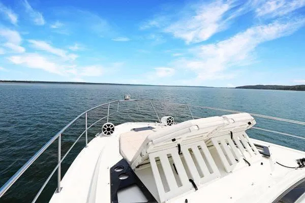 Slide: The Image of 2018 Cruisers Yachts 390 Express Coupe on open water under a clear blue sky. - 49