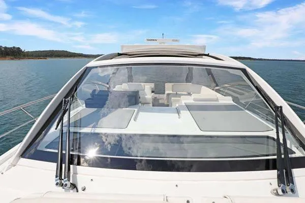 Slide: The Image of 2018 Cruisers Yachts 390 Express Coupe on serene water, showcasing sleek design and spacious deck. - 50
