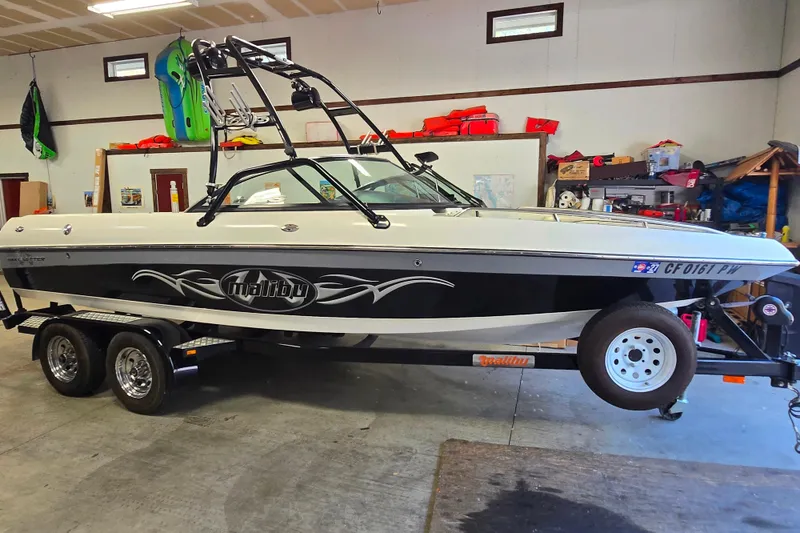 The Image of 2003 Malibu Sunscape 21 LSV boat on trailer in a garage setting. - 1