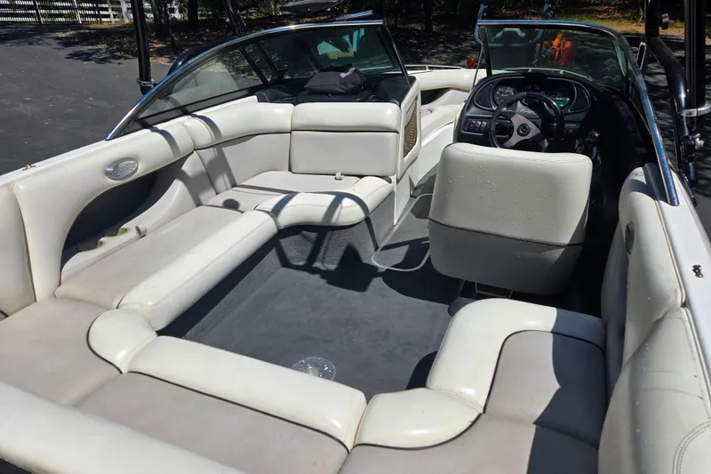 Slide: The Image of Interior of a 2003 Malibu Sunscape 21 LSV boat with white seating and steering console. - 13