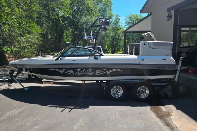 Slide: The Image of 2003 Malibu Sunscape 21 LSV boat on trailer, parked outdoors near house. - 16