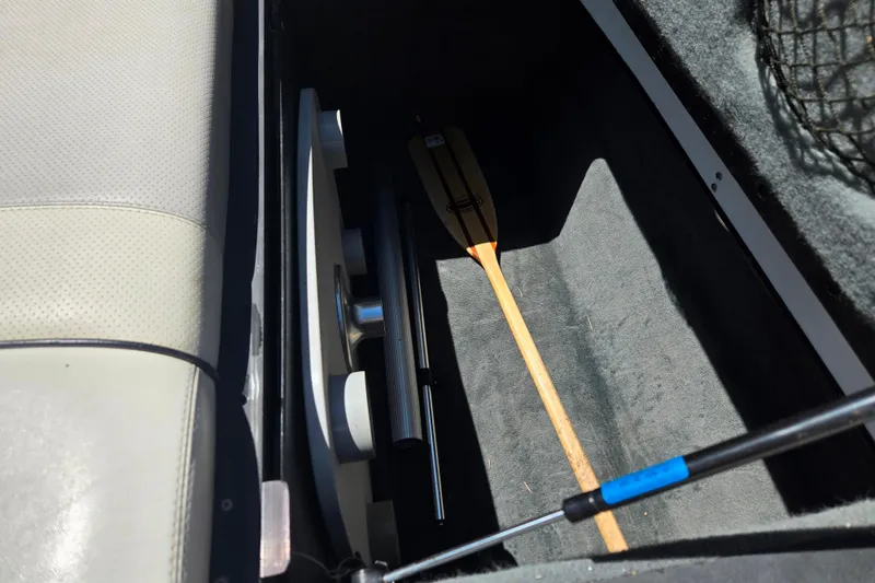 Slide: The Image of Storage compartment in a 2003 Malibu Sunscape 21 LSV boat with paddle and equipment. - 8