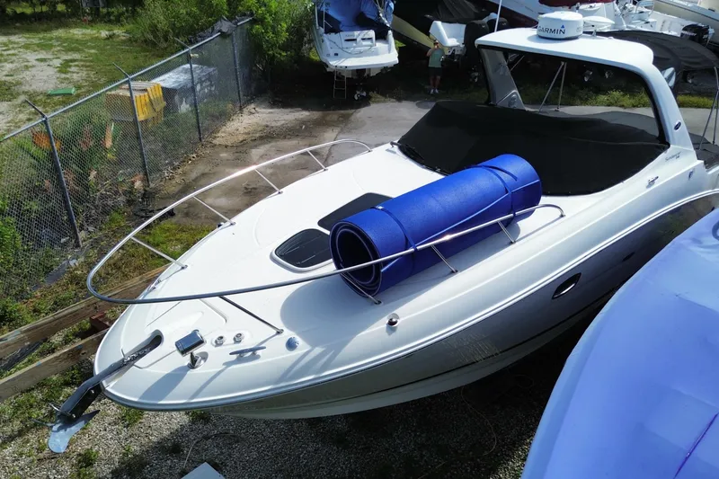 The Image of 2003 Monterey 302 Cruiser boat with blue mat on deck, parked outdoors. - 1