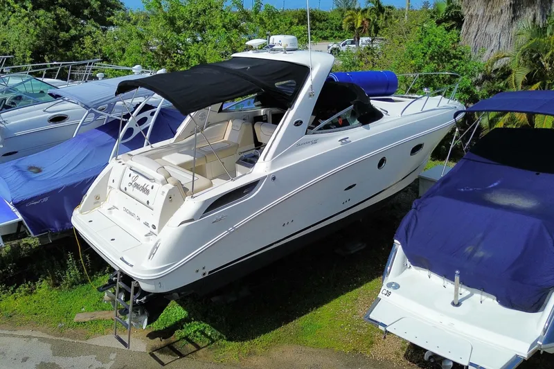 Slide: The Image of 2003 Monterey 302 Cruiser boat with black canopy, docked among other boats. - 11