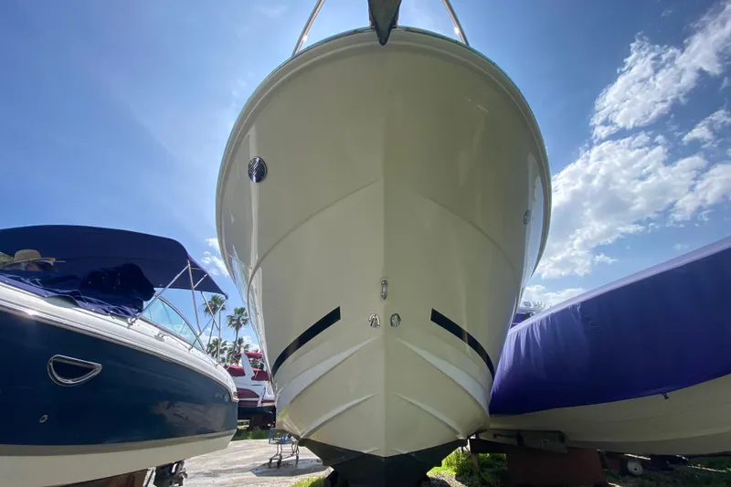Slide: The Image of 2003 Monterey 302 Cruiser boat on land, viewed from the front under a clear blue sky. - 25