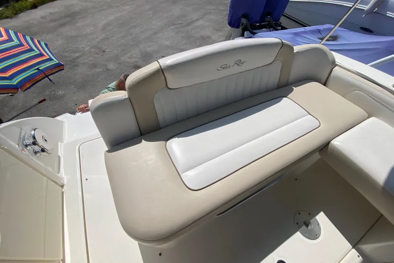 Slide: The Image of 2003 Monterey 302 Cruiser boat interior with beige and white seating, docked outdoors. - 28