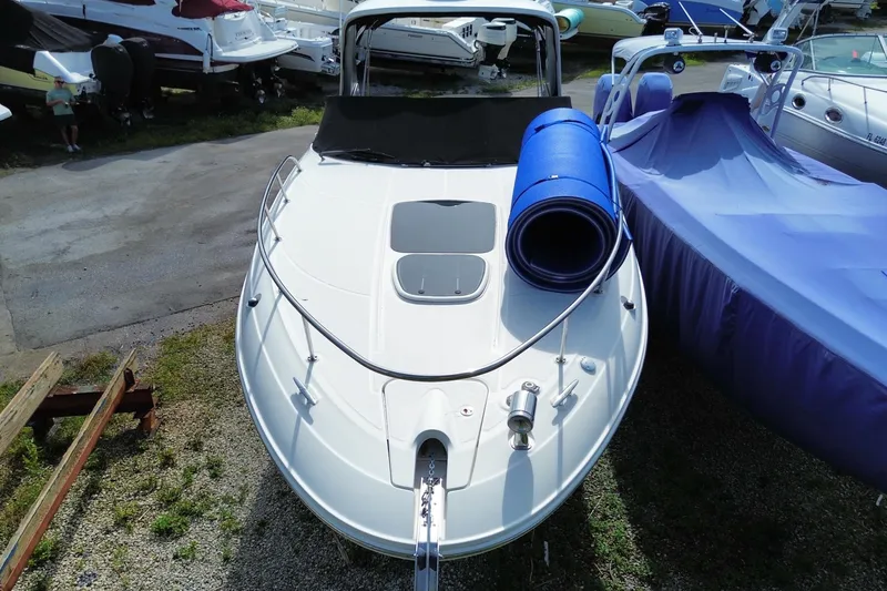 Slide: The Image of 2003 Monterey 302 Cruiser boat docked, featuring a sleek white deck and blue cover. - 3