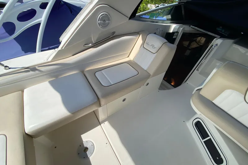 Slide: The Image of Interior seating of a 2003 Monterey 302 Cruiser boat, featuring beige upholstery. - 34