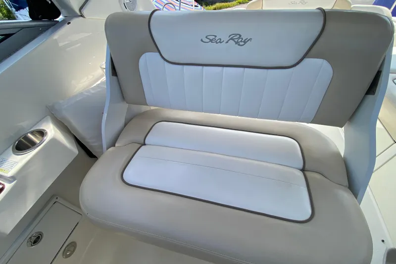 Slide: The Image of White and beige boat seat with "Sea Ray" logo, inside a 2003 Monterey 302 Cruiser. - 38