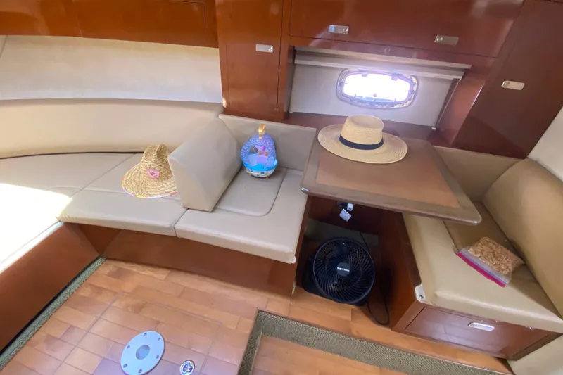 Slide: The Image of Interior of 2003 Monterey 302 Cruiser with seating, table, and hats on display. - 45