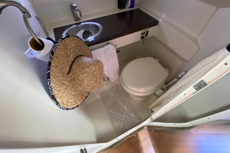 Slide: The Image of Compact bathroom in a 2003 Monterey 302 Cruiser with a straw hat and toilet paper. - 48