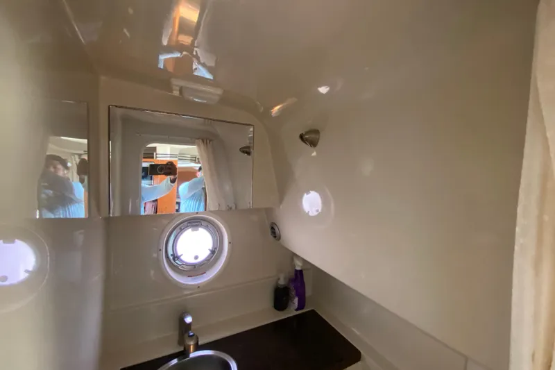 Slide: The Image of Interior of 2003 Monterey 302 Cruiser bathroom with sink, mirror, and porthole window. - 50