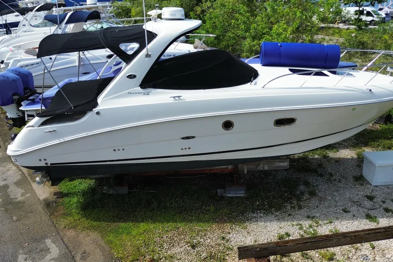 Slide: The Image of White 2003 Monterey 302 Cruiser boat on dry dock, surrounded by other vessels. - 7