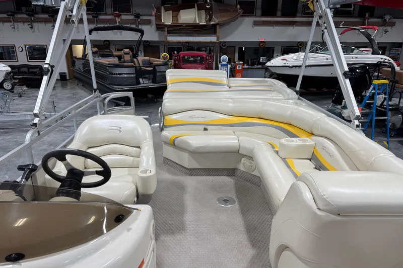Slide: The Image of 2005 Bennington 2575 RL pontoon boat interior with plush seating and steering console. - 10
