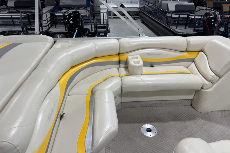 Slide: The Image of 2005 Bennington 2575 RL boat interior with cream and yellow seating, featuring cup holders. - 11