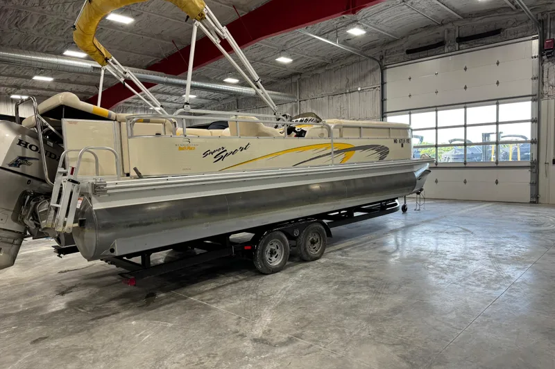 Slide: The Image of 2005 Bennington 2575 RL pontoon boat on trailer in a spacious indoor garage. - 3