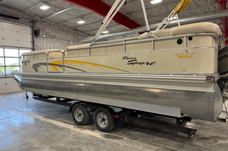 Slide: The Image of 2005 Bennington 2575 RL pontoon boat in a garage, featuring "Super Sport" design. - 4