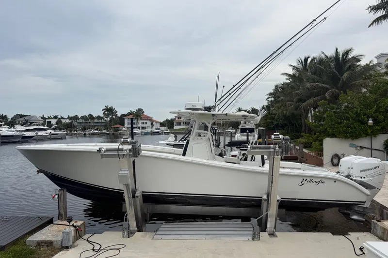 The Image of 2006 Yellowfin 34 Offshore boat docked near waterfront homes and palm trees. - 30