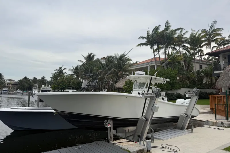Slide: The Image of 2006 Yellowfin 34 Offshore boat docked near palm trees and waterfront homes. - 32