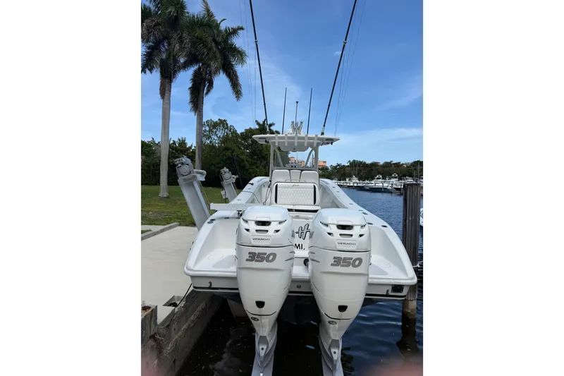 Slide: The Image of 2006 Yellowfin 34 Offshore boat with twin 350 Verado engines docked by palm trees. - 35