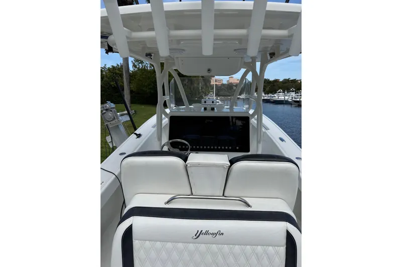 Slide: The Image of 2006 Yellowfin 34 Offshore boat interior with white seating and steering console. - 37